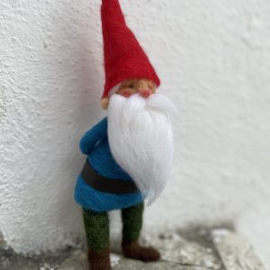 Gnomo dei boschi natalizio di lana cardata con pantaloni verdi e giubba blu e una lunga barba bianca e cappello rosso